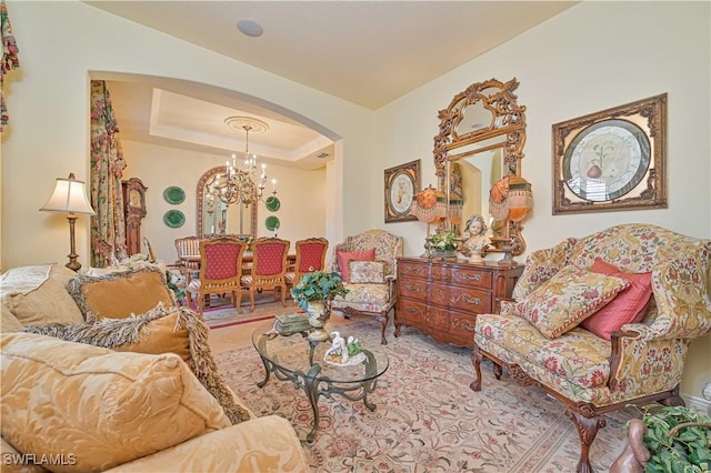 living room featuring an inviting chandelier and a tray ceiling