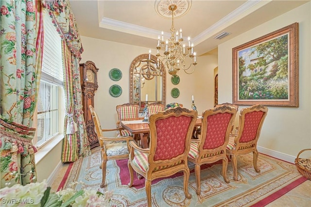 dining area with crown molding, a raised ceiling, and a chandelier