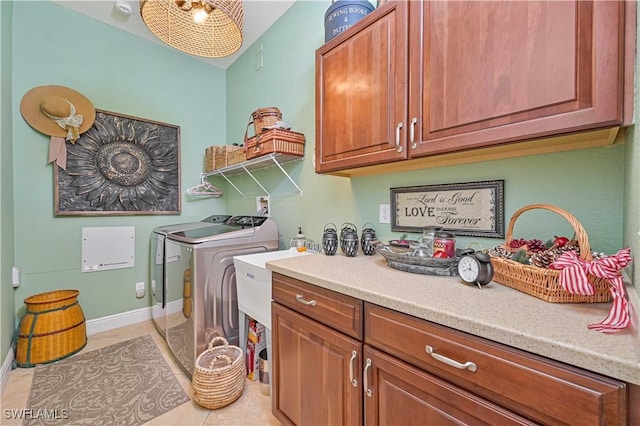 laundry area with cabinets, washer and dryer, and light tile patterned floors