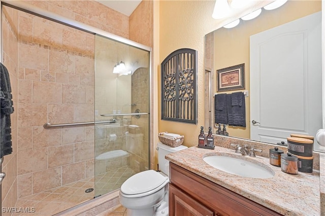 bathroom featuring vanity, toilet, and a shower with shower door