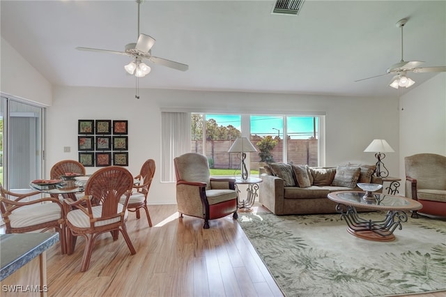 living room with ceiling fan, lofted ceiling, and light wood-type flooring