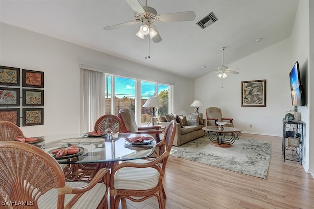 dining space with light hardwood / wood-style floors, vaulted ceiling, and ceiling fan