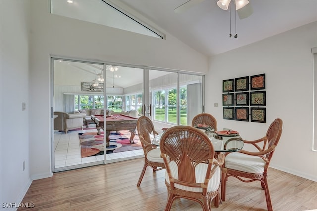 dining room with light hardwood / wood-style flooring, vaulted ceiling, and ceiling fan