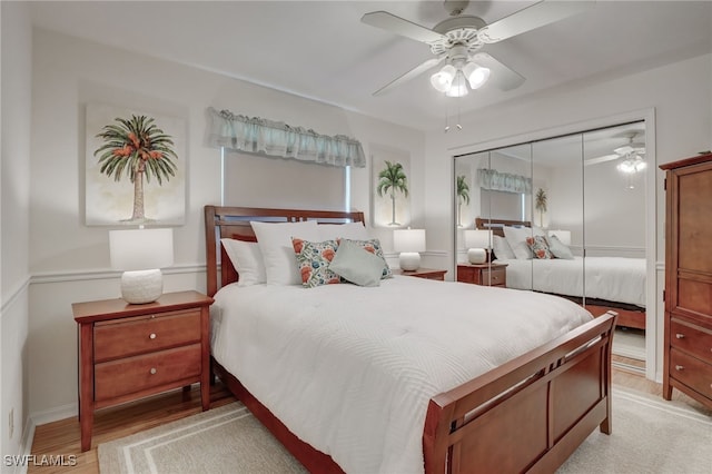 bedroom with light wood-type flooring, a closet, and ceiling fan