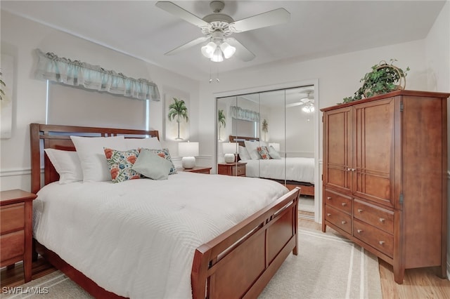 bedroom featuring light hardwood / wood-style floors, a closet, and ceiling fan