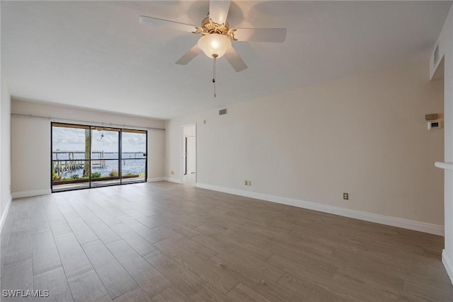 empty room featuring hardwood / wood-style floors and ceiling fan