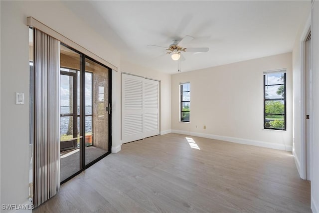 spare room featuring ceiling fan, plenty of natural light, and light hardwood / wood-style flooring