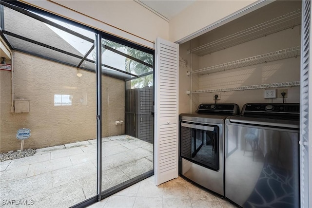 clothes washing area with light tile patterned floors and independent washer and dryer