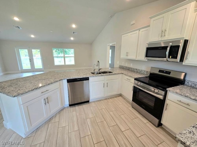 3102 E 2nd St, Lehigh Acres, FL 33936 - kitchen featuring appliances with stainless steel finishes, a sink, a peninsula, white cabinets, and light stone counters