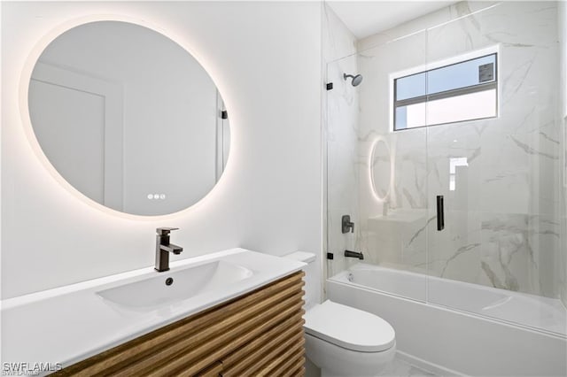 full bathroom with combined bath / shower with glass door, vanity, and toilet