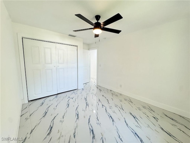 unfurnished bedroom featuring ceiling fan and a closet