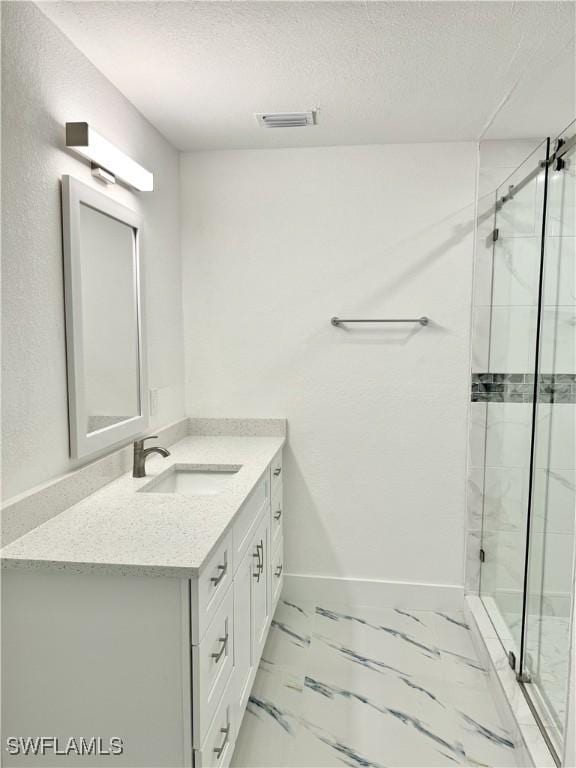 bathroom featuring vanity, a textured ceiling, and walk in shower