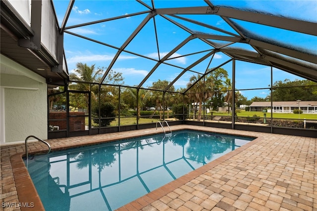 view of pool featuring glass enclosure, a patio area, and a hot tub