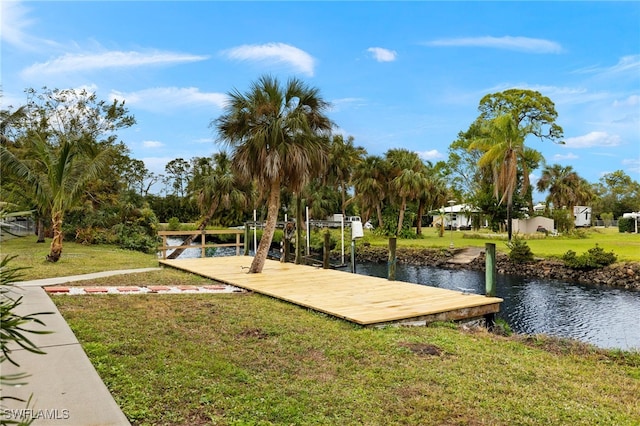 surrounding community featuring a dock, a water view, and a lawn