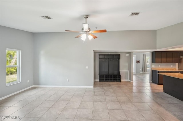 unfurnished living room featuring light tile patterned flooring and ceiling fan