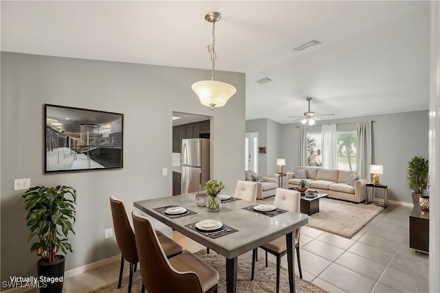 dining area featuring light tile patterned flooring, vaulted ceiling, and ceiling fan