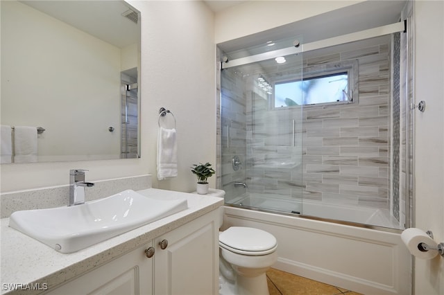 bathroom featuring vanity, visible vents, tile patterned flooring, toilet, and combined bath / shower with glass door