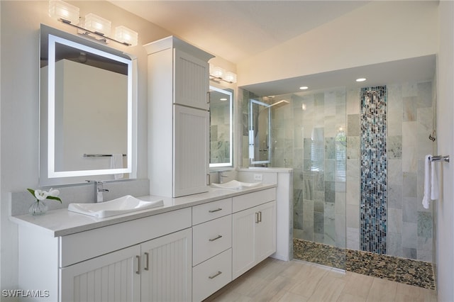 full bathroom featuring double vanity, a walk in shower, and a sink