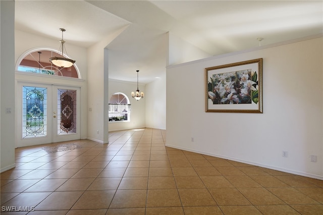 foyer entrance with french doors, baseboards, a notable chandelier, and tile patterned flooring