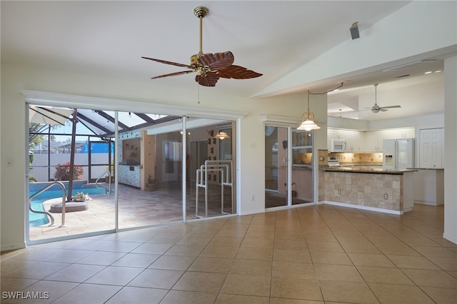 interior space featuring a lanai, an outdoor pool, exterior kitchen, and ceiling fan