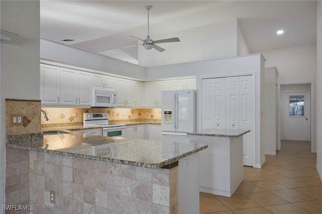 kitchen with white appliances, light tile patterned floors, a peninsula, a sink, and backsplash