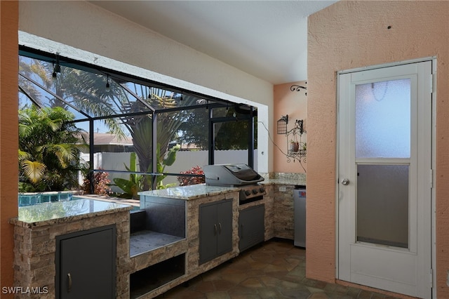 view of patio featuring area for grilling, glass enclosure, and a grill