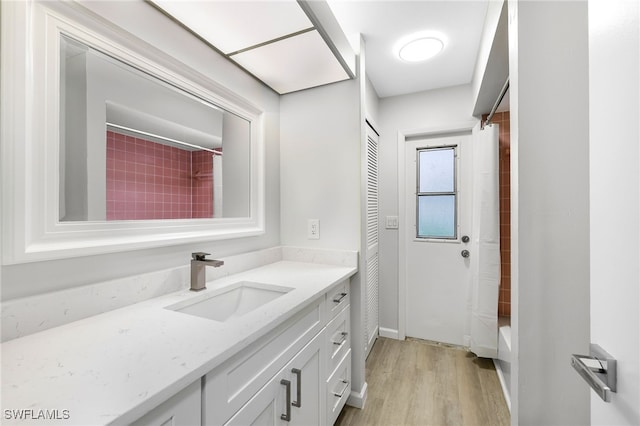 bathroom with vanity, shower / bathtub combination with curtain, and wood-type flooring