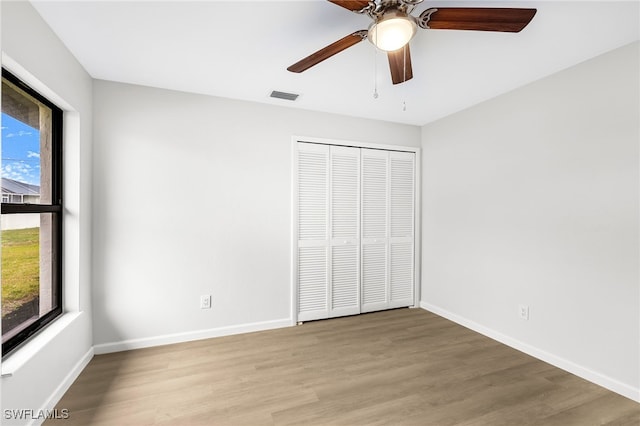 unfurnished bedroom with light hardwood / wood-style floors, a closet, and ceiling fan