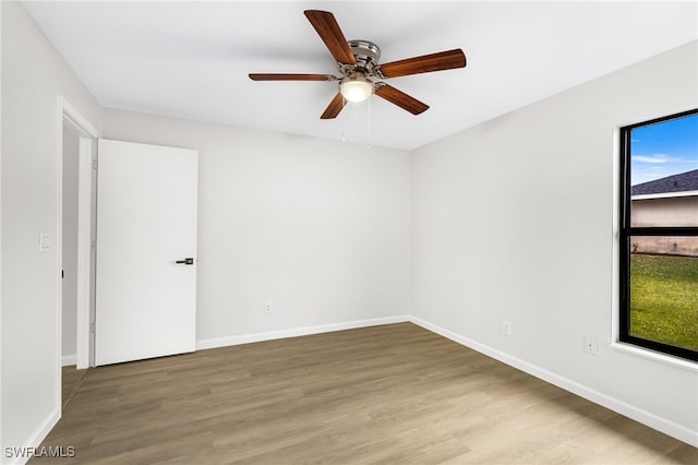 empty room with ceiling fan and hardwood / wood-style floors