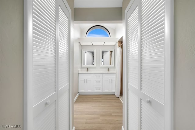 hallway with sink and light hardwood / wood-style floors