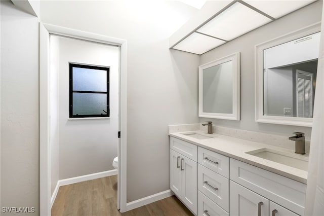 bathroom with hardwood / wood-style floors, toilet, and vanity