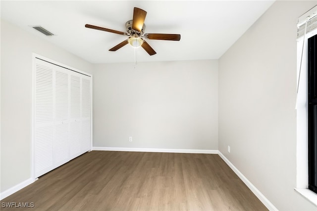 unfurnished bedroom with ceiling fan, hardwood / wood-style flooring, and a closet