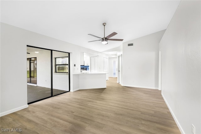 unfurnished living room with light hardwood / wood-style flooring, vaulted ceiling, and ceiling fan