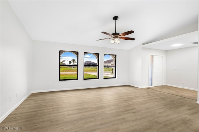 spare room with hardwood / wood-style flooring, lofted ceiling, and ceiling fan