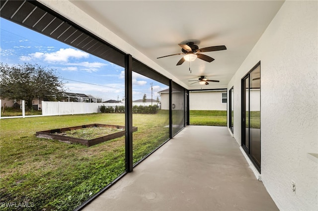 unfurnished sunroom with ceiling fan