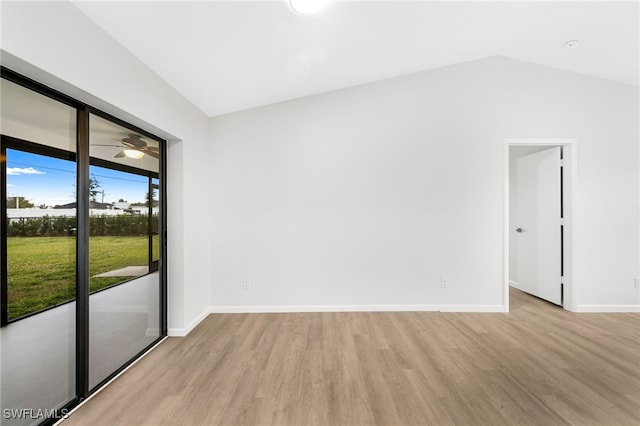 spare room featuring light wood-type flooring and lofted ceiling