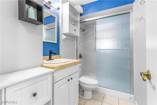 bathroom featuring vanity, tile patterned floors, toilet, and walk in shower