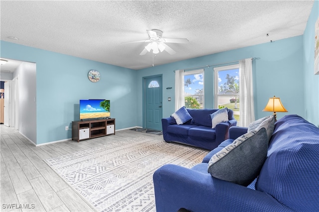 living room featuring wood-type flooring, a textured ceiling, and ceiling fan