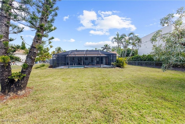 view of yard with a fenced in pool and glass enclosure