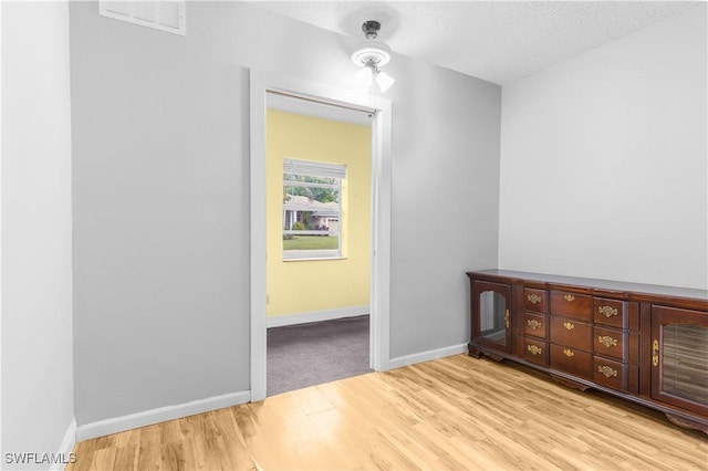 interior space featuring a textured ceiling and light hardwood / wood-style floors