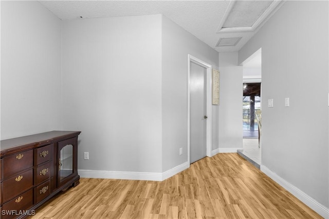 corridor featuring a textured ceiling and light wood-type flooring