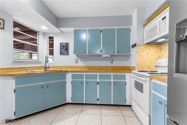 kitchen featuring sink, white appliances, tasteful backsplash, a textured ceiling, and blue cabinets