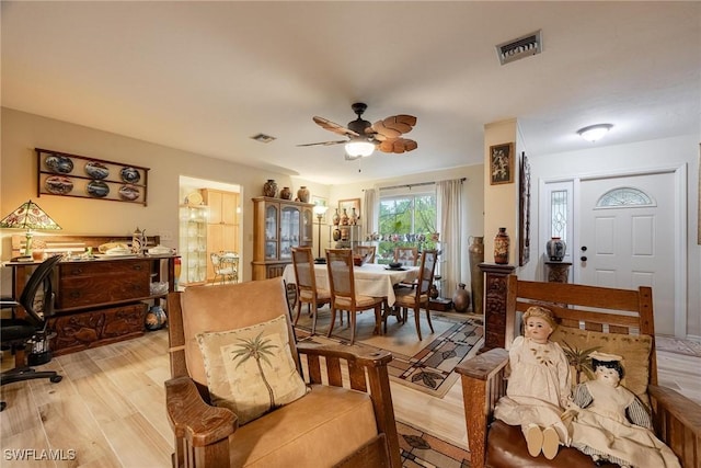 living room with ceiling fan and light wood-type flooring