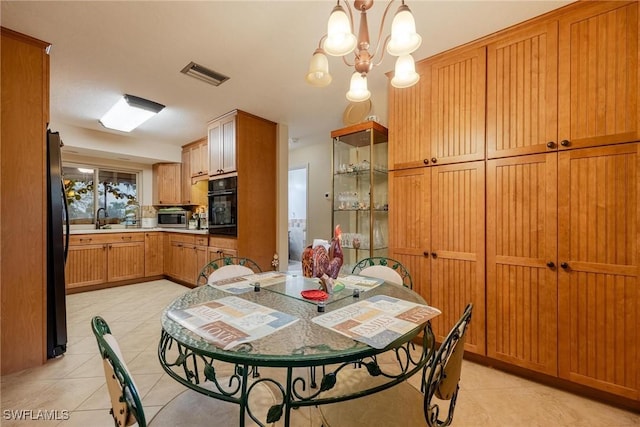 dining area with sink, a chandelier, and light tile patterned floors