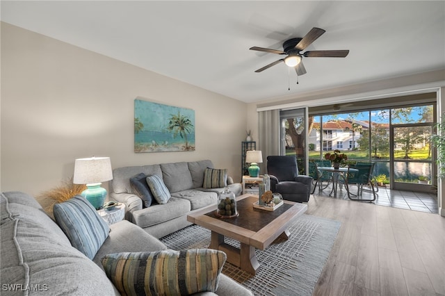 living room with light wood-type flooring and ceiling fan