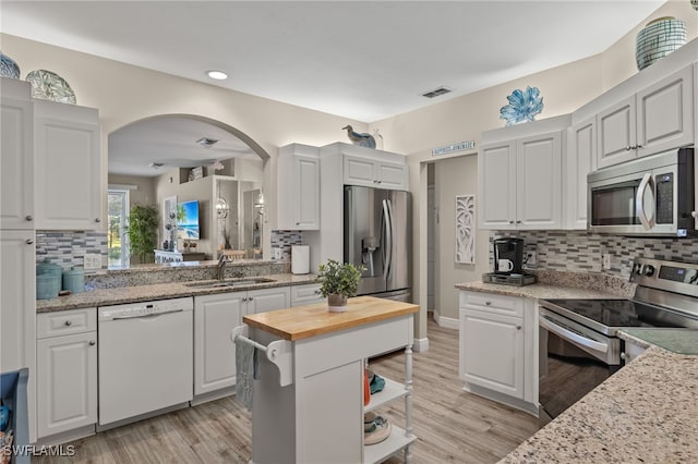 kitchen featuring white cabinets, stainless steel appliances, wood counters, and sink