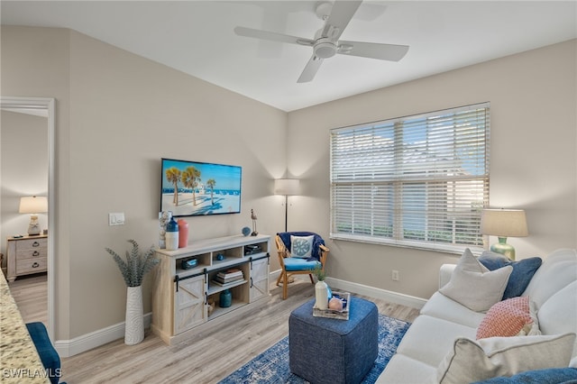 living room featuring light hardwood / wood-style flooring and ceiling fan