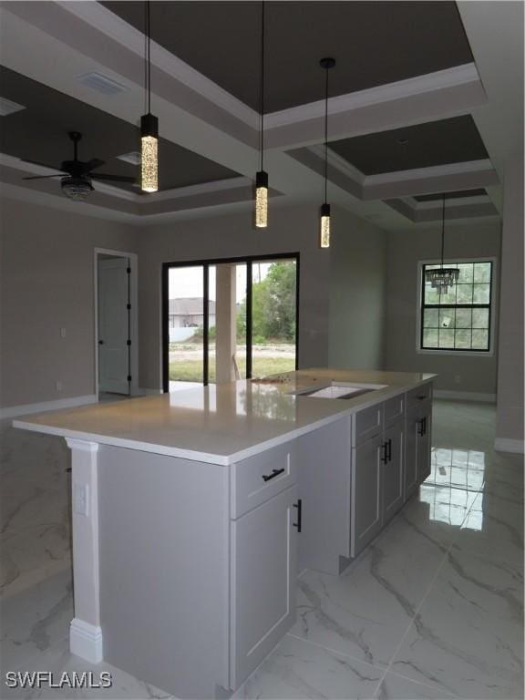 kitchen featuring a kitchen island, pendant lighting, and a tray ceiling