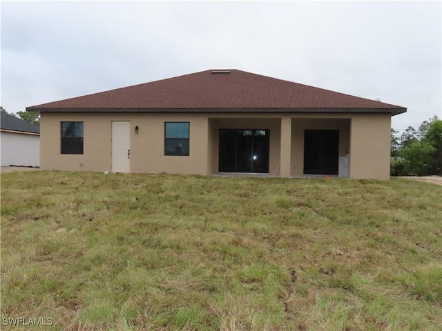 rear view of property with a yard