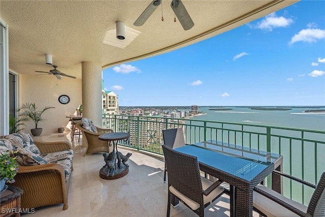 balcony with a water view and ceiling fan